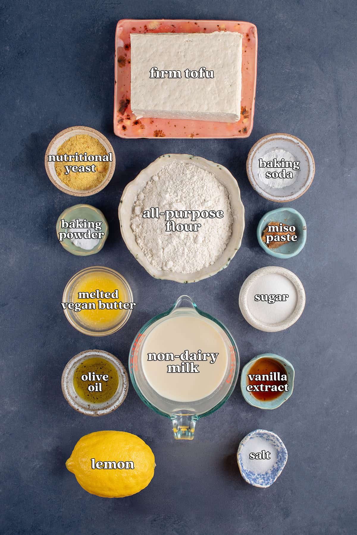 firm tofu, nutritional yeast, all-purpose flour, baking soda, baking powder, miso paste, melted vegan butter, sugar, olive oil, non-dairy milk, vanilla extract, lemon, salt