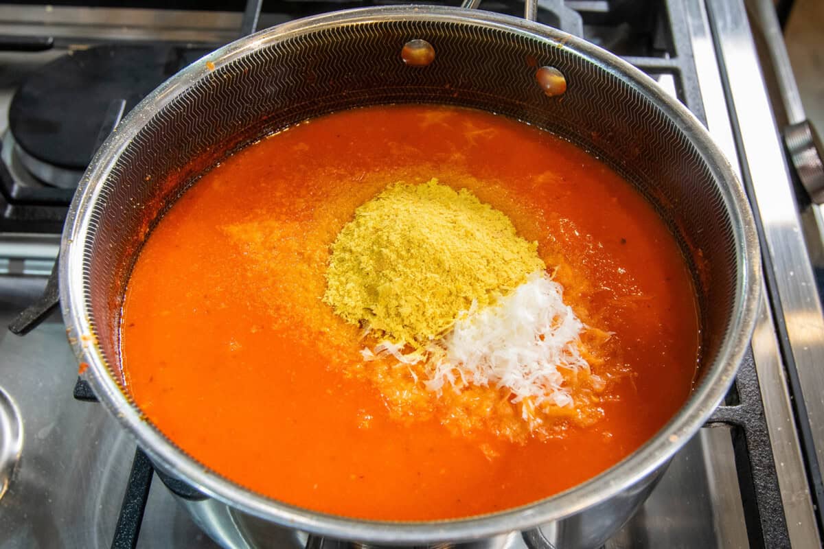 nutritional yeast and vegan parmesan added to pot of vodka tomato soup