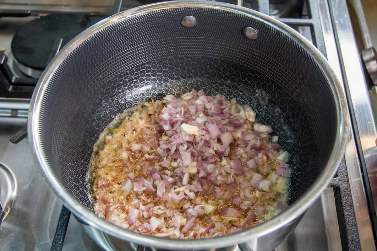 adding shallots to pot