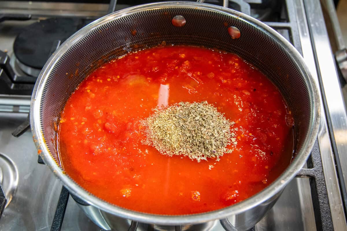 adding Italian seasoning to pot of soup