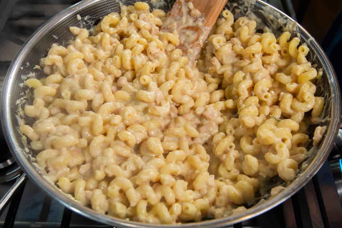 pot of creamy white and rosemary pasta in a pot with wooden spatula