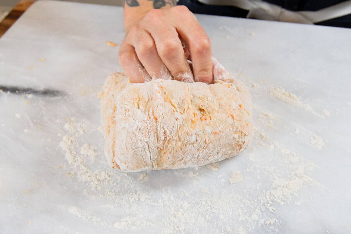 kneading the cinnamon roll dough on a marble surface
