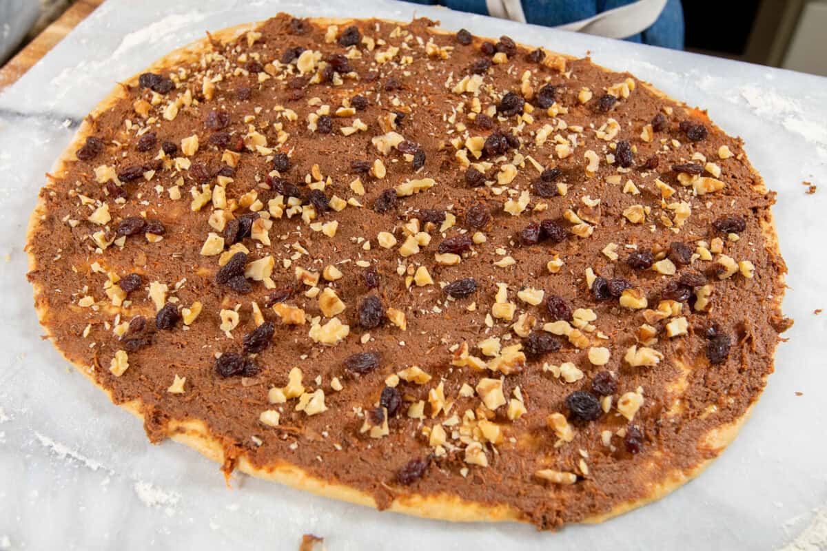 walnuts and raisins sprinkled across the cinnamon roll dough