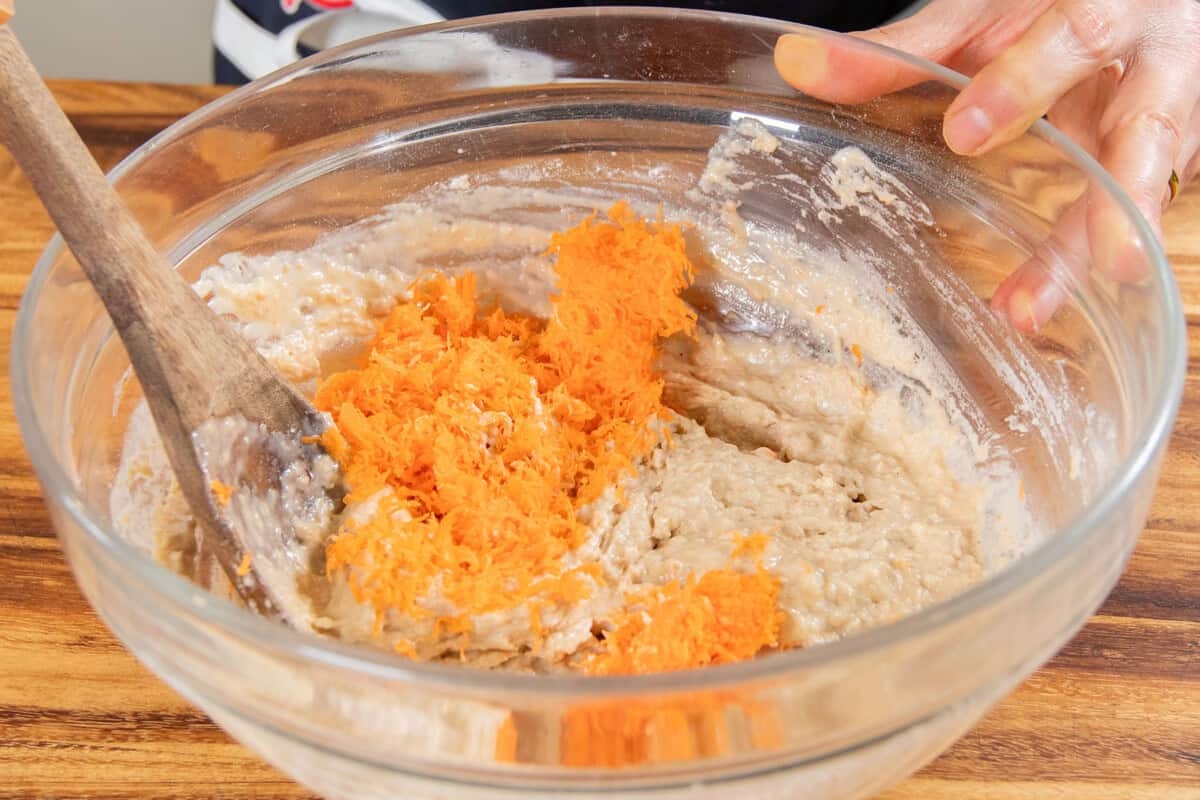 adding shredded carrots in to the bowl