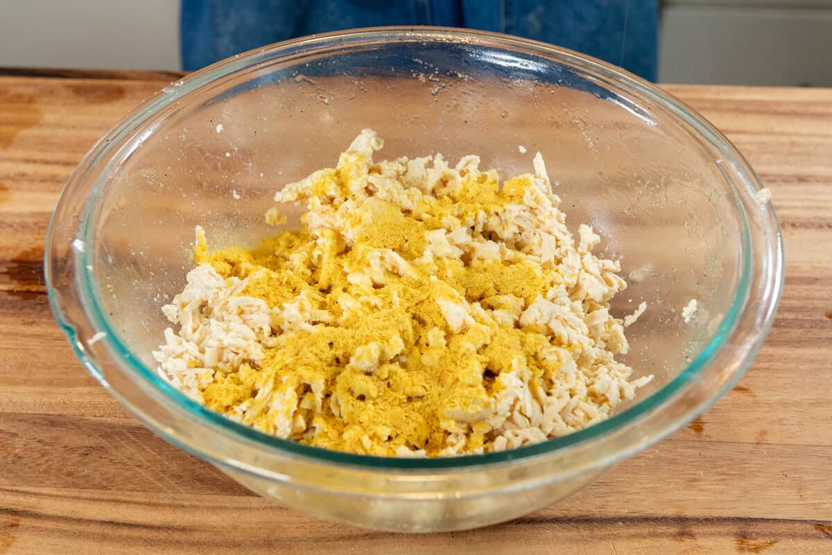 mixing ingredients for vegan ricotta salata in large glass bowl