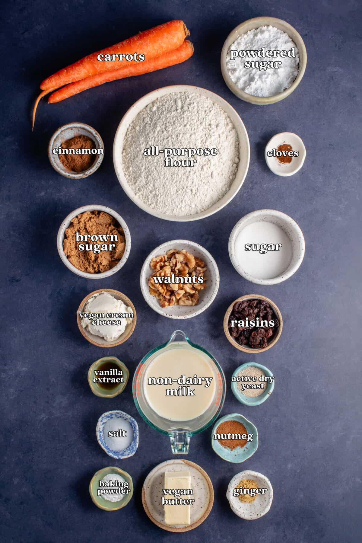 carrots, powdered sugar, cinnamon, all-purpose flour, cloves, brown sugar, walnuts, sugar, vegan cream cheese, raisins, vanilla extract, non-dairy milk, active dry yeast, salt, nutmeg, baking powder, vegan butter, ginger