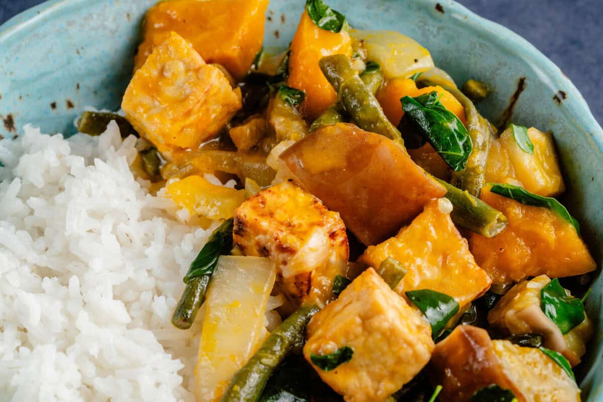 close up of a bowl of ginataang gulay with tofu and a side of rice