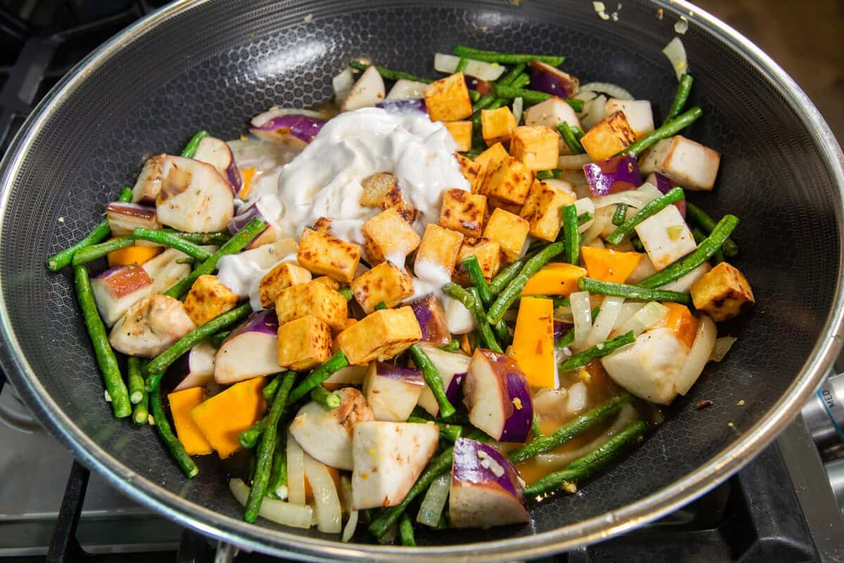 adding tofu and coconut milk to the pot