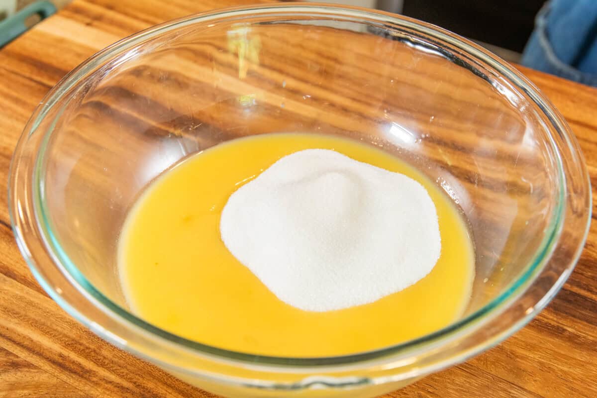 adding sugar to melted butter in large bowl