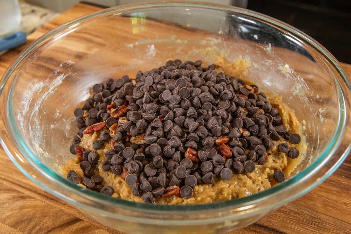 adding pecans and chocolate chips to cookie dough