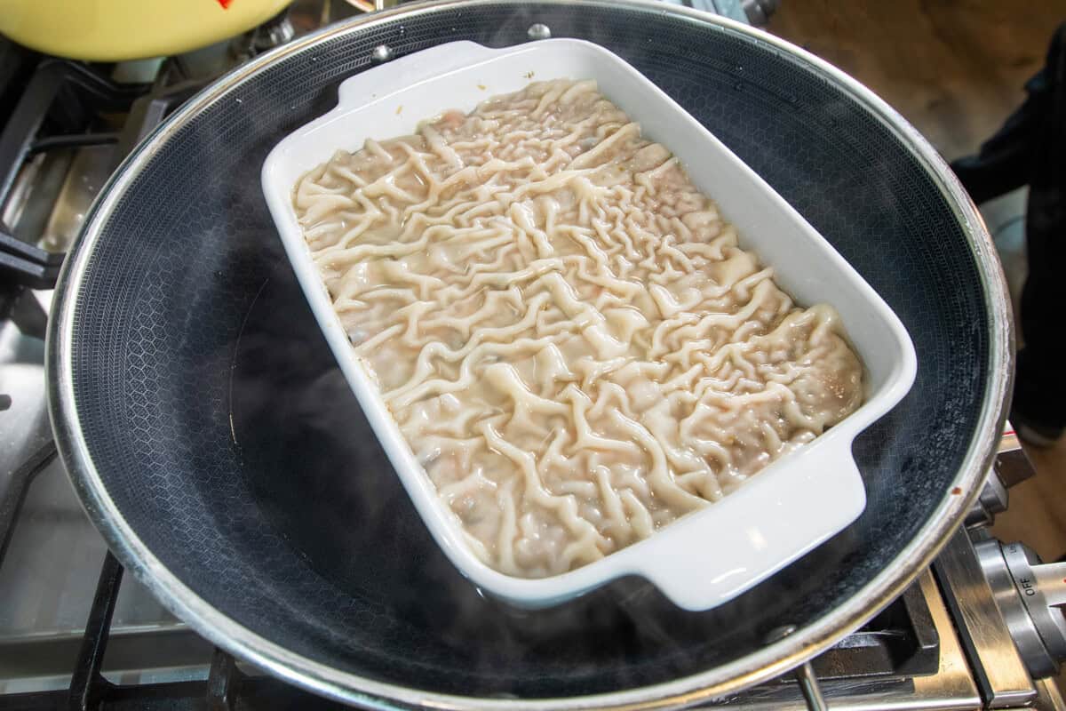 steaming the dumpling lasagna in a large pot