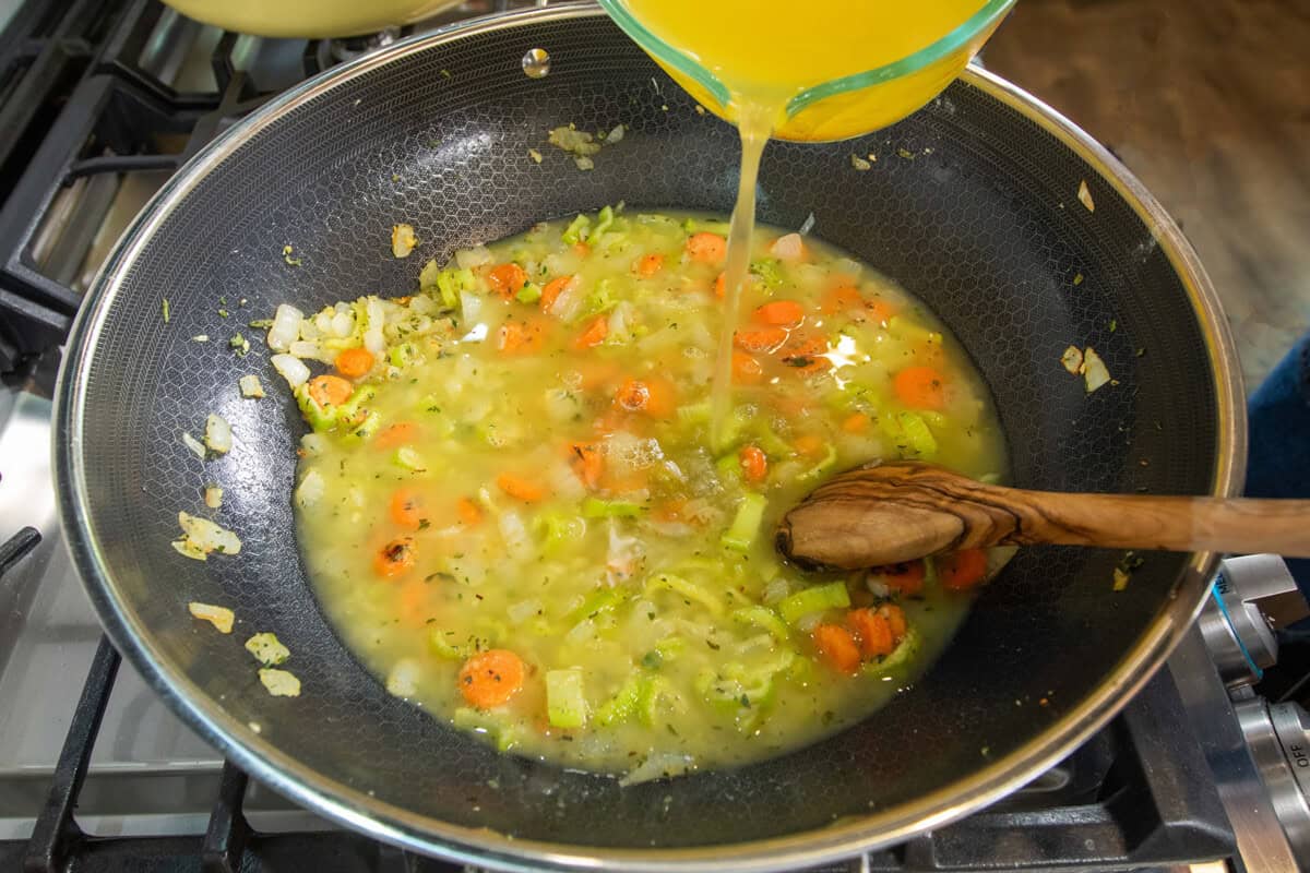 adding broth into the pot