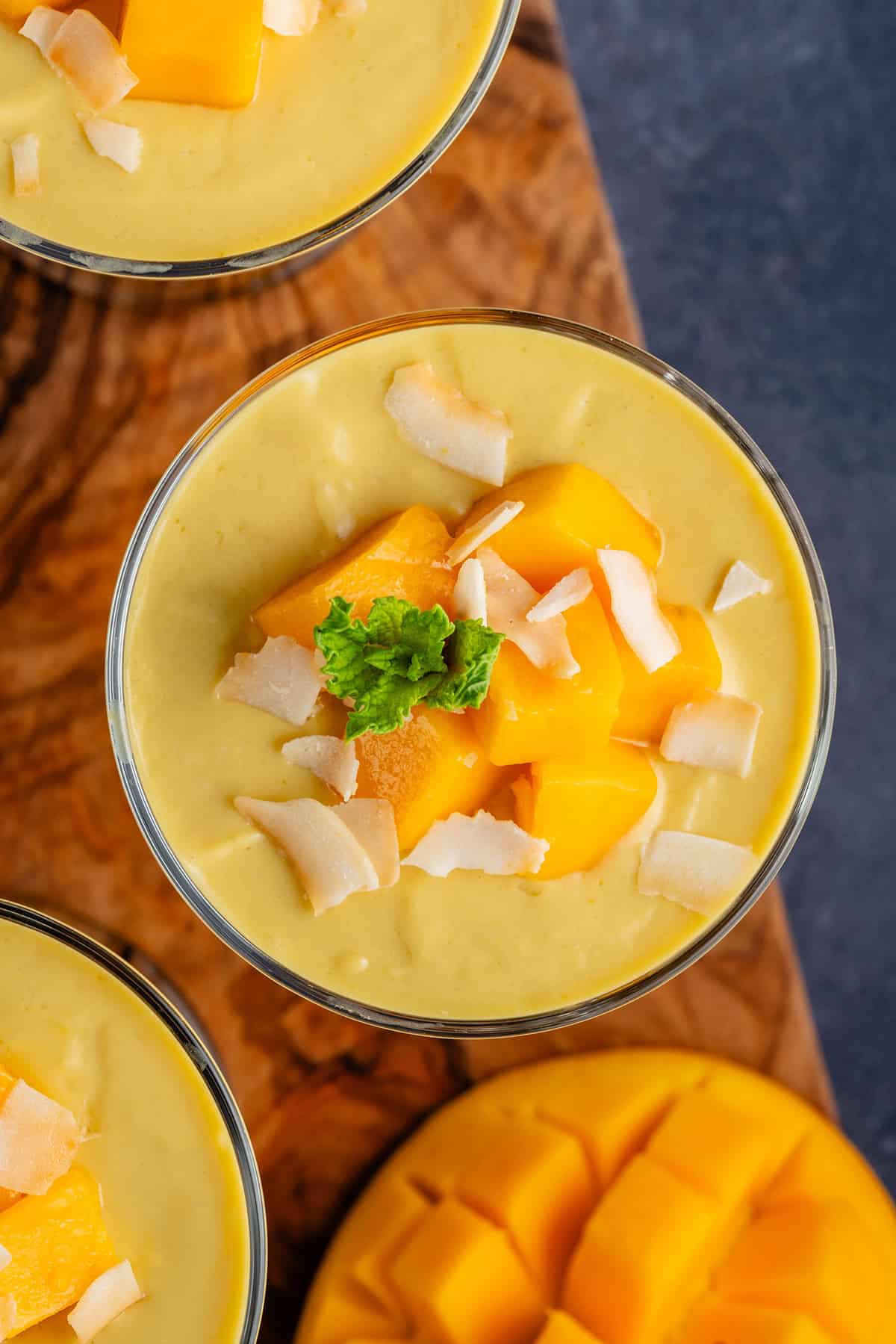 overhead of mango posset topped with mango, coconut and mint