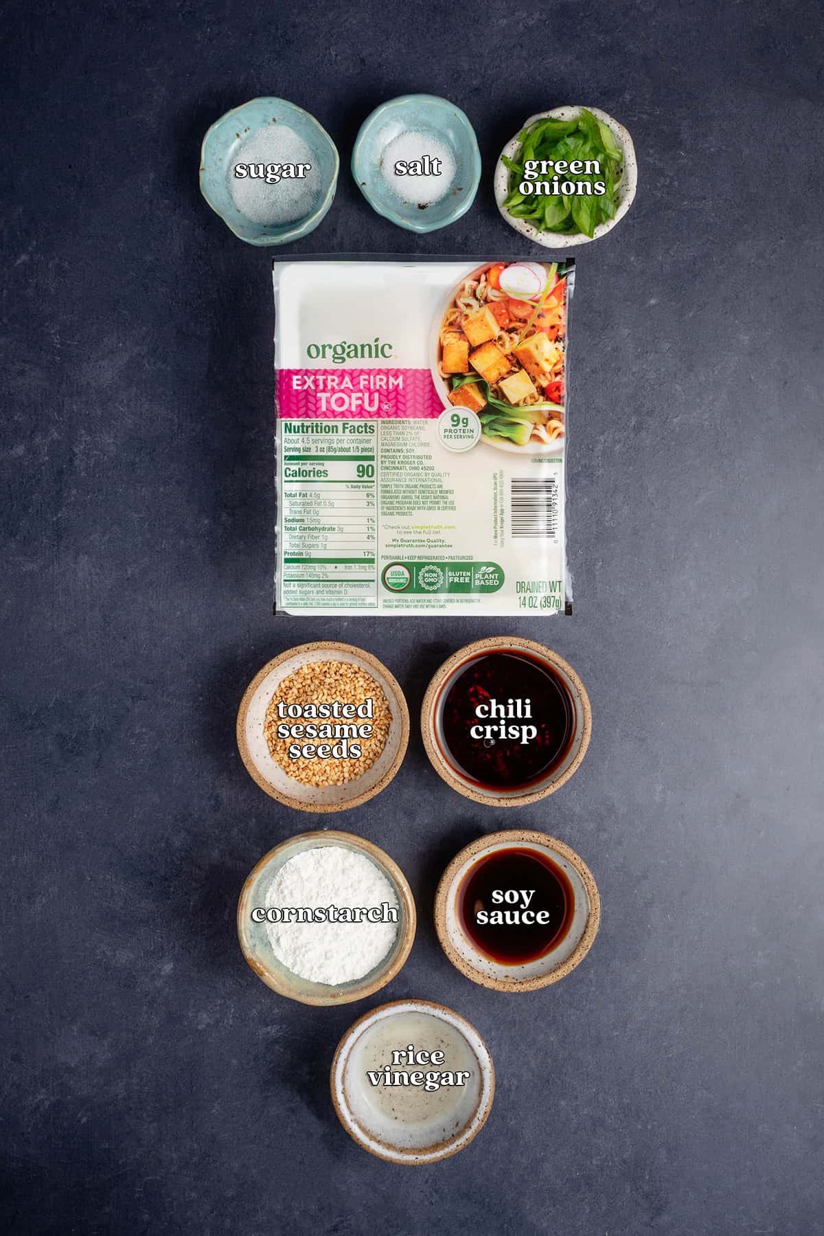 labeled ingredients for chili crisp tofu: sugar, salt, green onions, extra firm tofu, toasted sesame seeds, chili crisp, cornstarch, soy sauce, rice vinegar