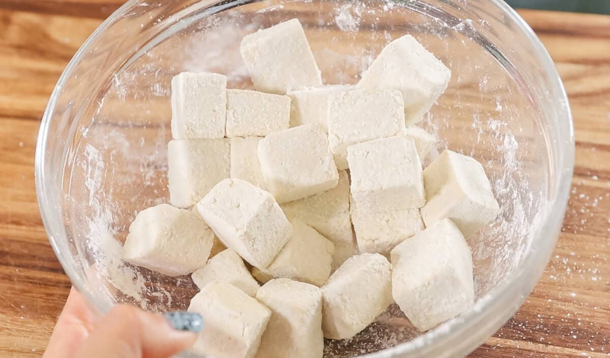 diced tofu in glass bowl coated in cornstarch