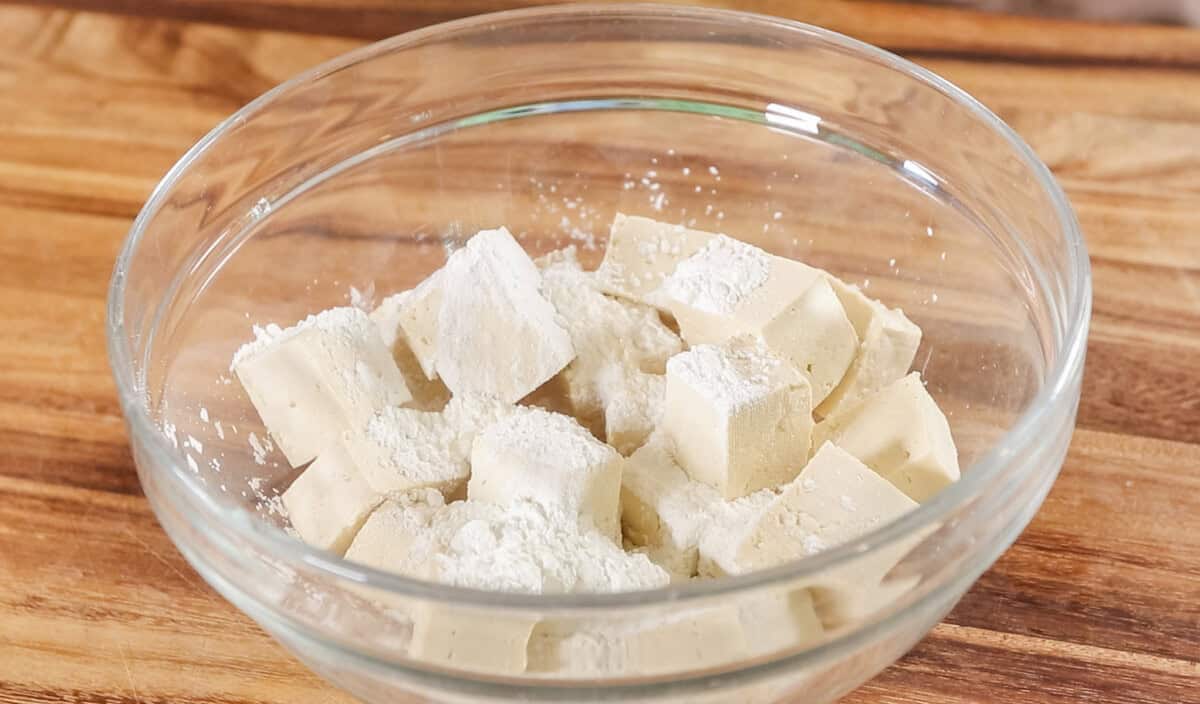 diced tofu in glass bowl with cornstarch on top
