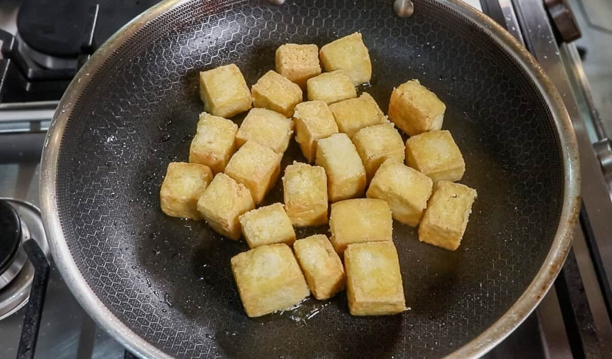 golden fried tofu in black pan