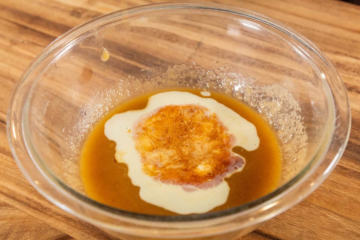 adding vanilla and soy milk to bowl