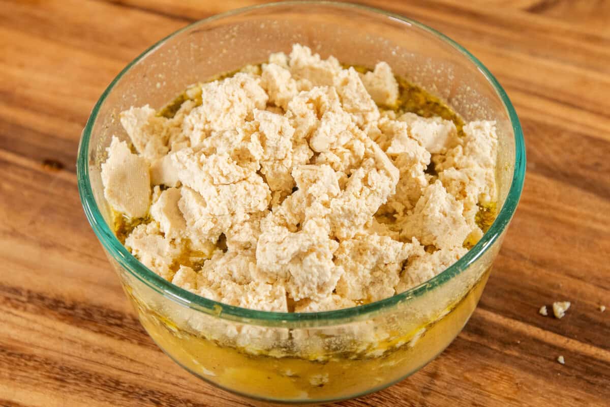 adding crumbled tofu to marinade