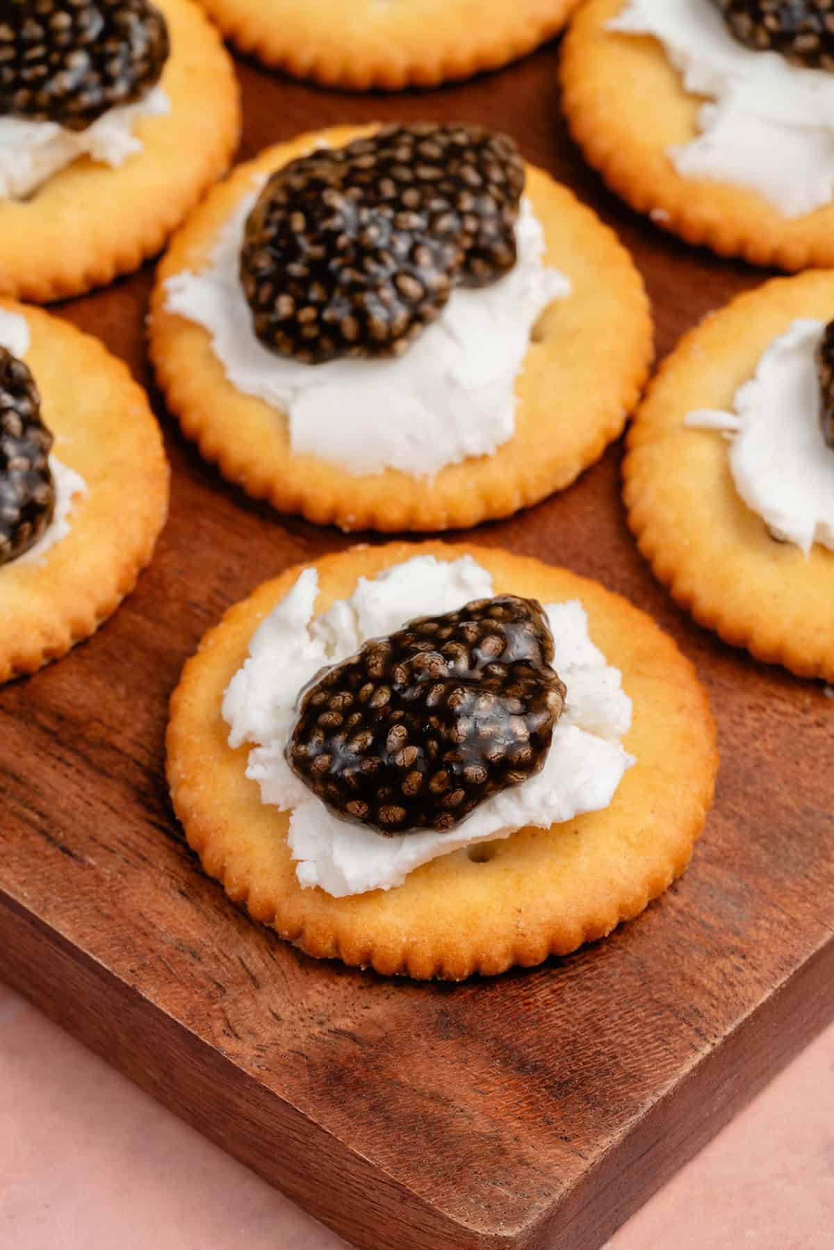 close up of vegan chia seed caviar on crackers with cream cheese