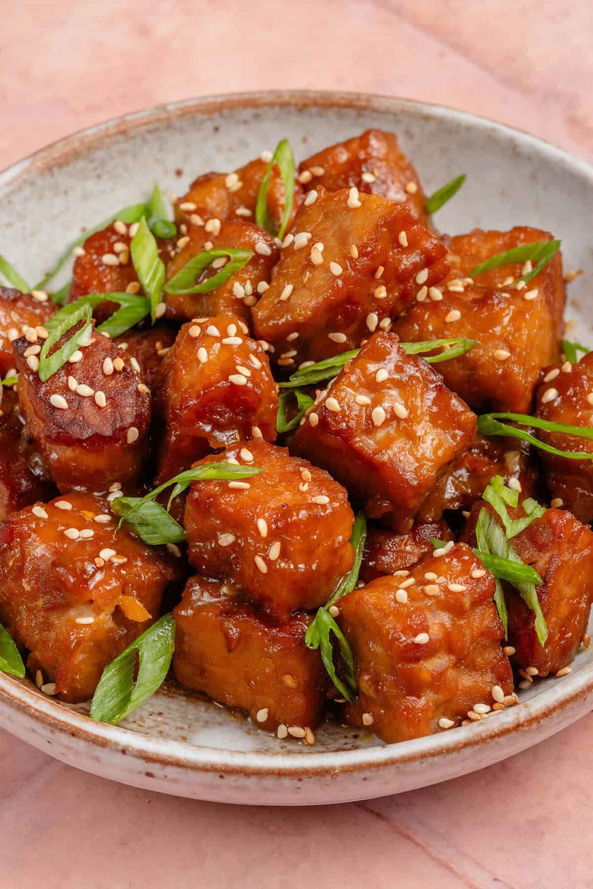 miso maple braised tempeh topped with sesame seeds and scallions