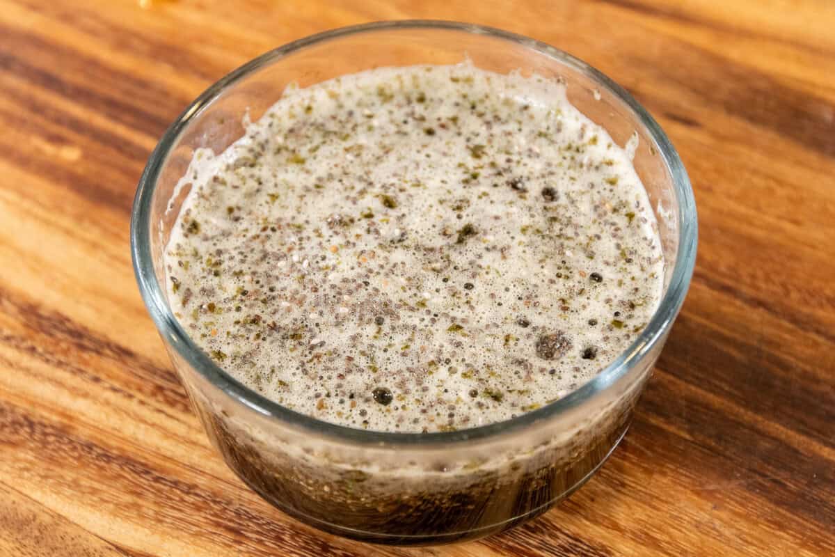 pouring water over the chia seeds in a small bowl