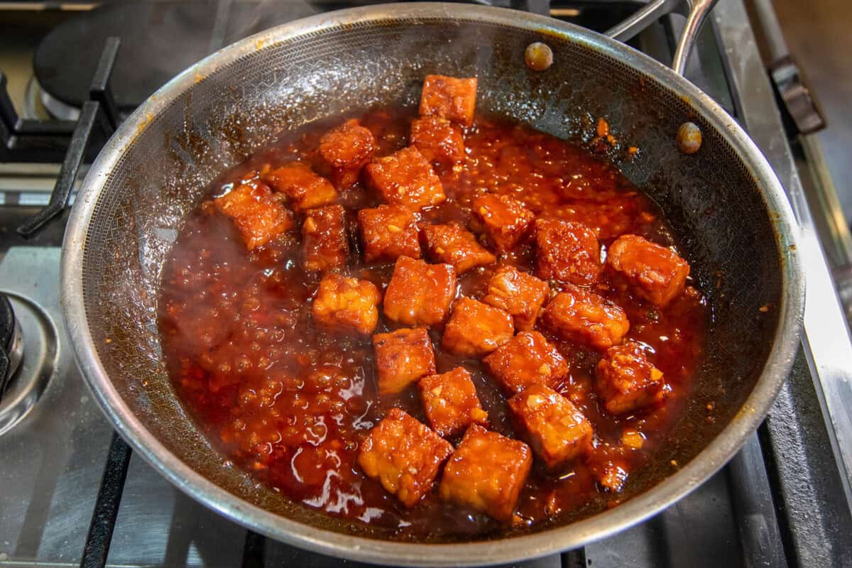 braising tempeh in gochujang sauce in a skillet