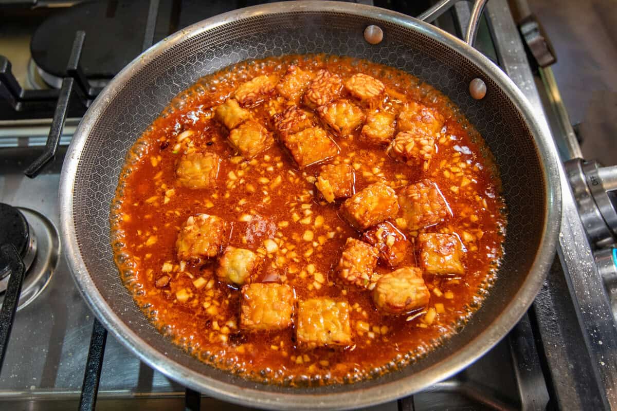 adding sauce to the skillet