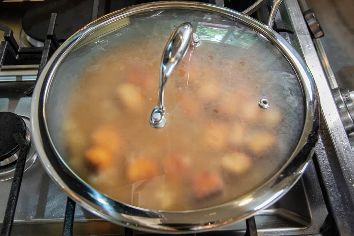 skillet with lid with tempeh braising inside