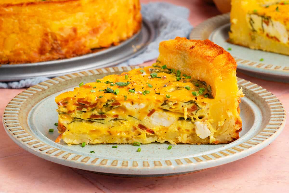 close up of slice of potato crust quiche on a plate showing the inside