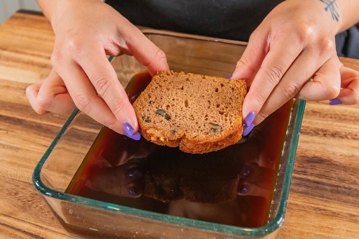 dunking a slice of banana bread in the coffee mixture