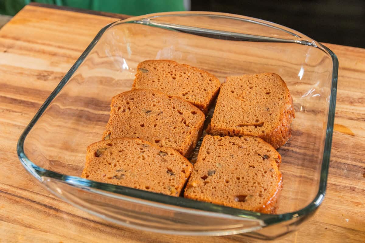 lining a baking dish with slices of coffee soaked banana bread