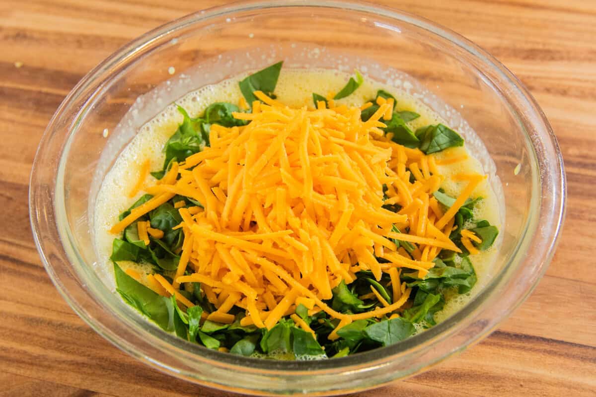 filling ingredients in a bowl with vegan cheddar cheese on top