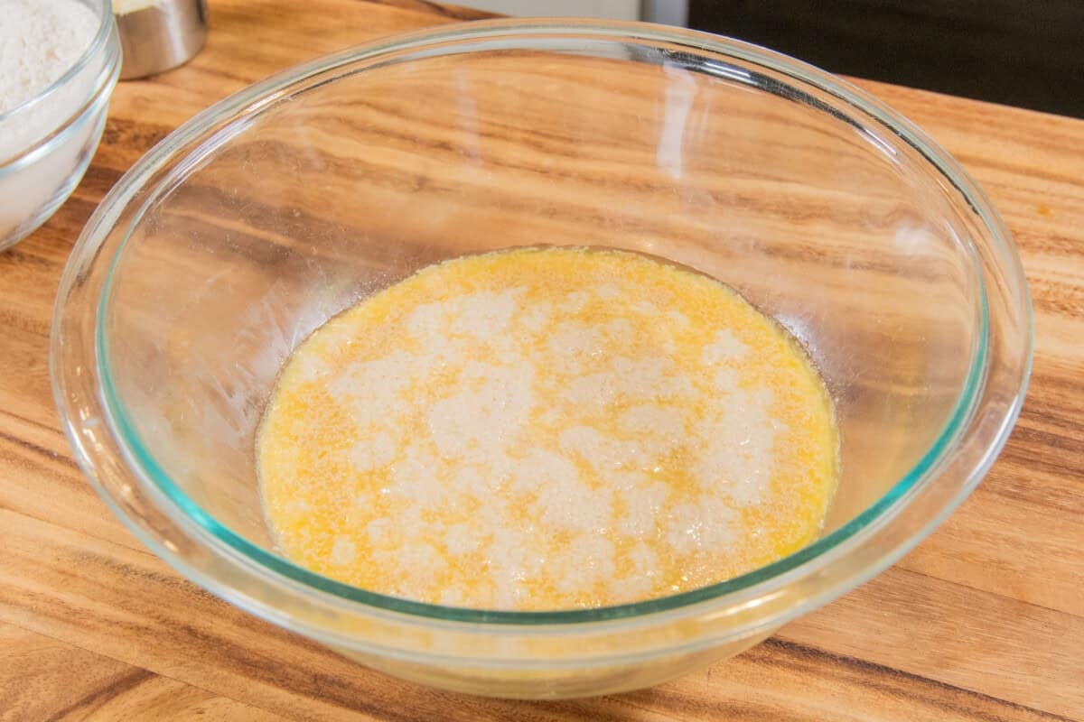 activated yeast in glass bowl with non-dairy milk, sugar and vegan butter