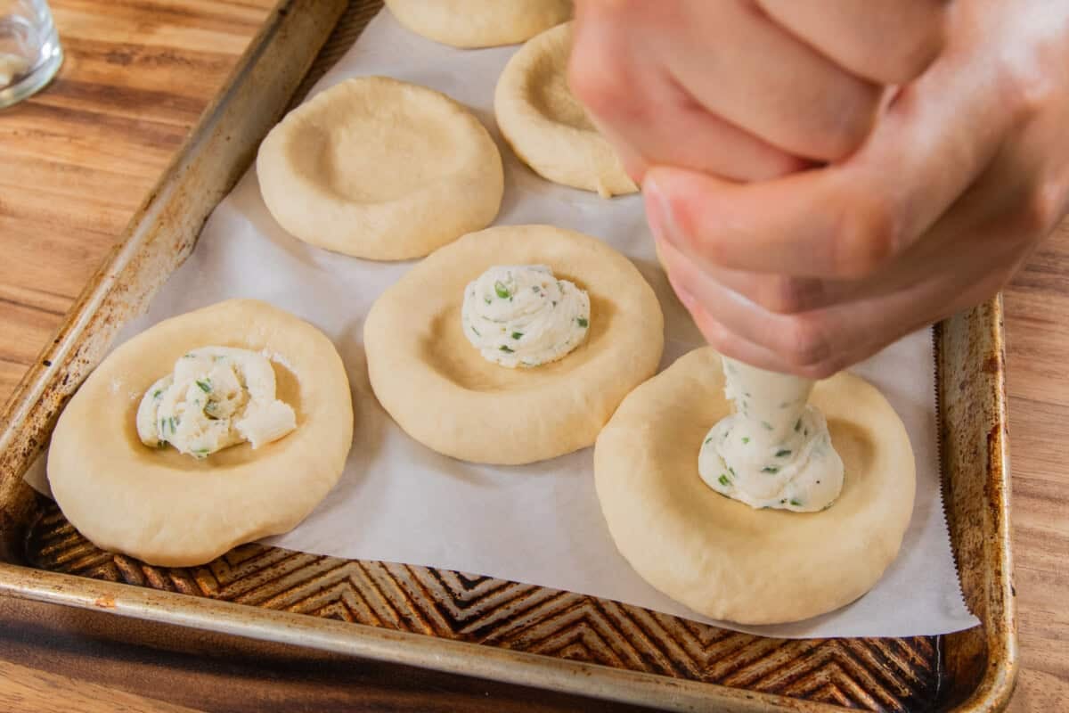 filling flattened dough with Chive Cream Cheese for Olive Chive Cream Cheese Rolls