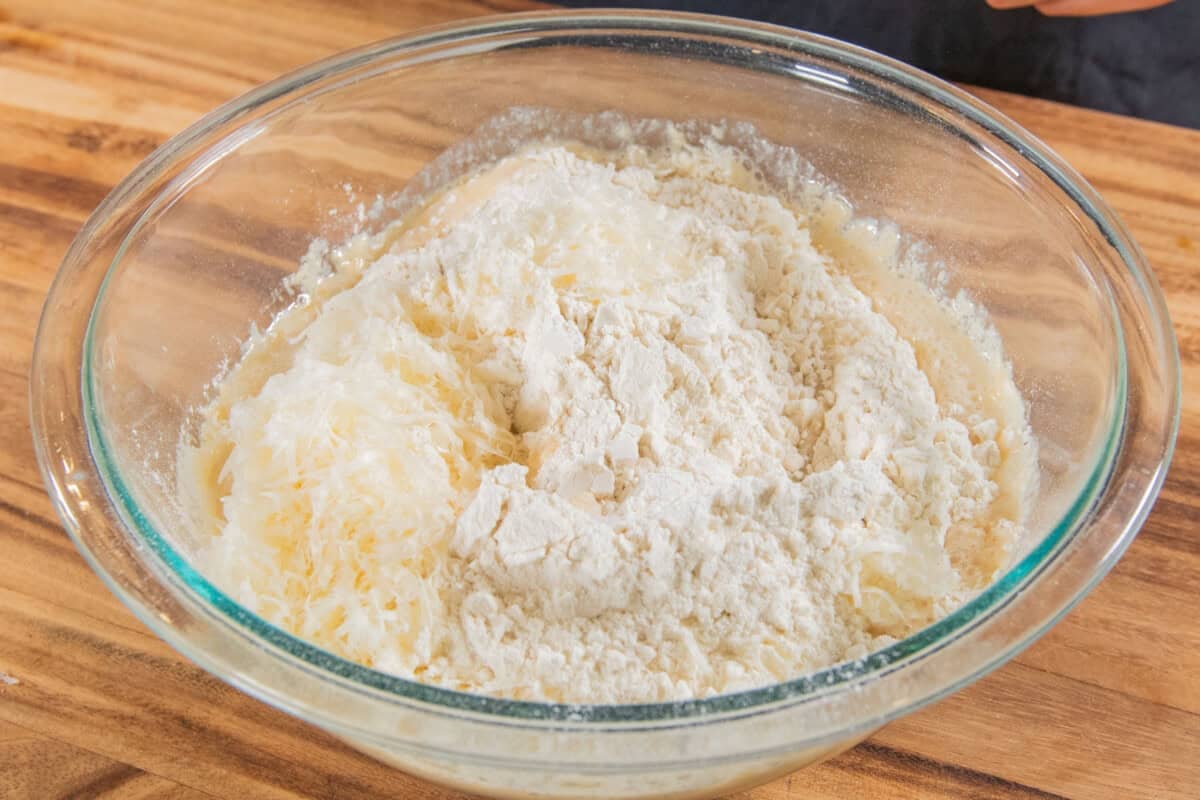 glass bowl filled with ingredients to make Olive Chive Cream Cheese Roll dough