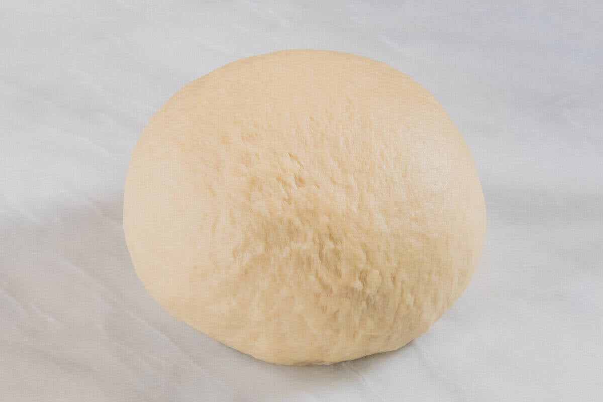 smooth dough for Olive Chive Cream Cheese Rolls on white marble surface
