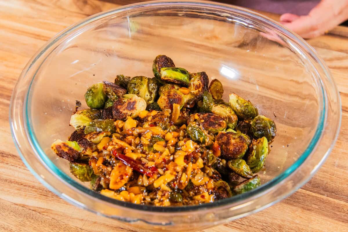 roasted brussels sprouts in a bowl with the chili crisp sauce added