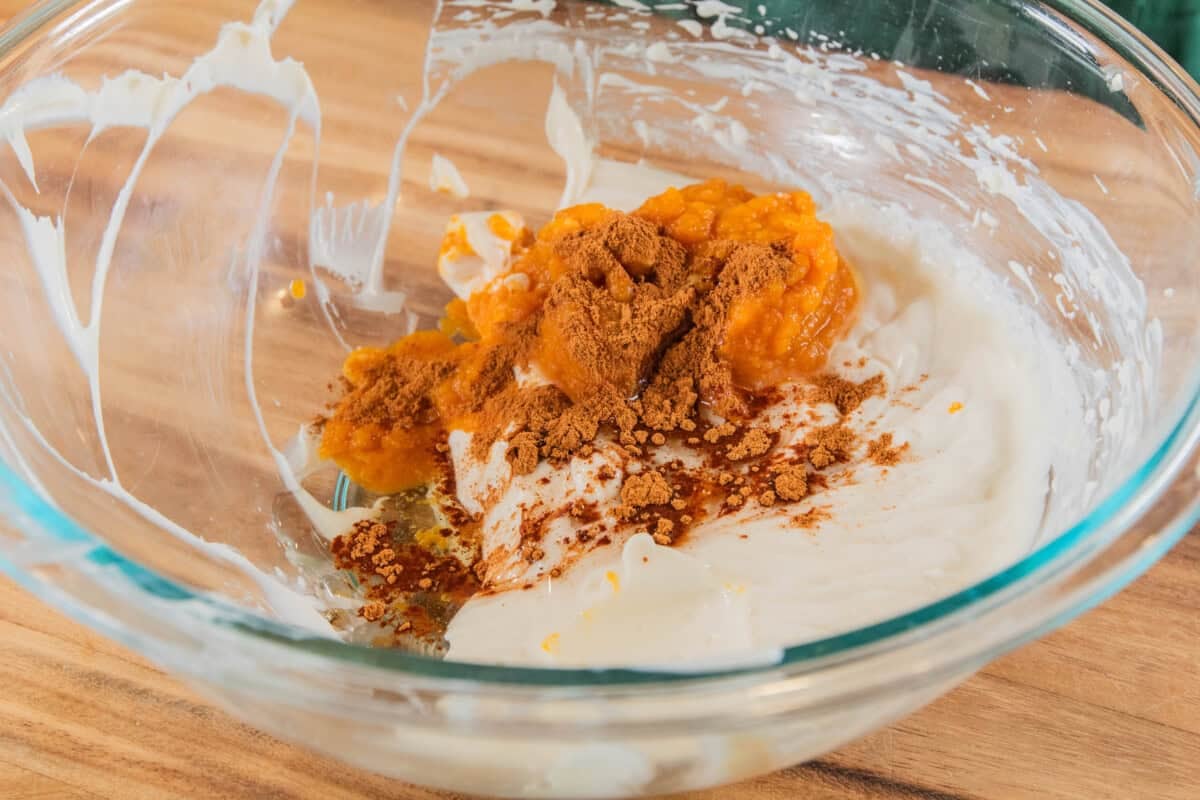 ingredients for a pumpkin cheesecake bar filling in glass bowl before mixing