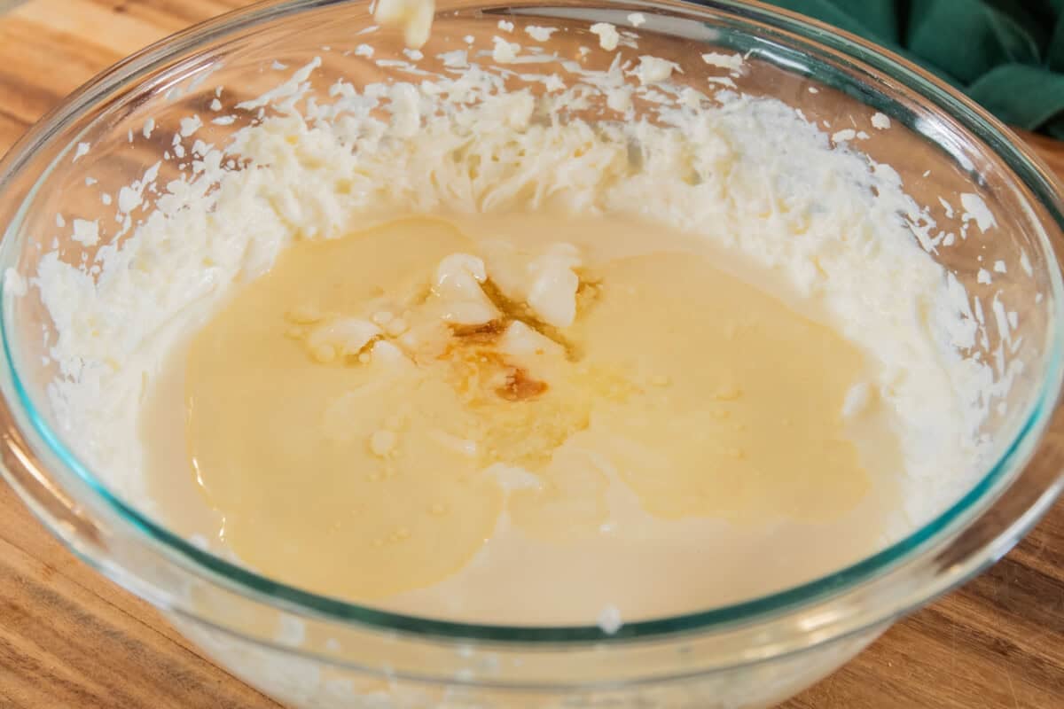 ingredients for a pumpkin cheesecake bar filling in glass bowl before mixing