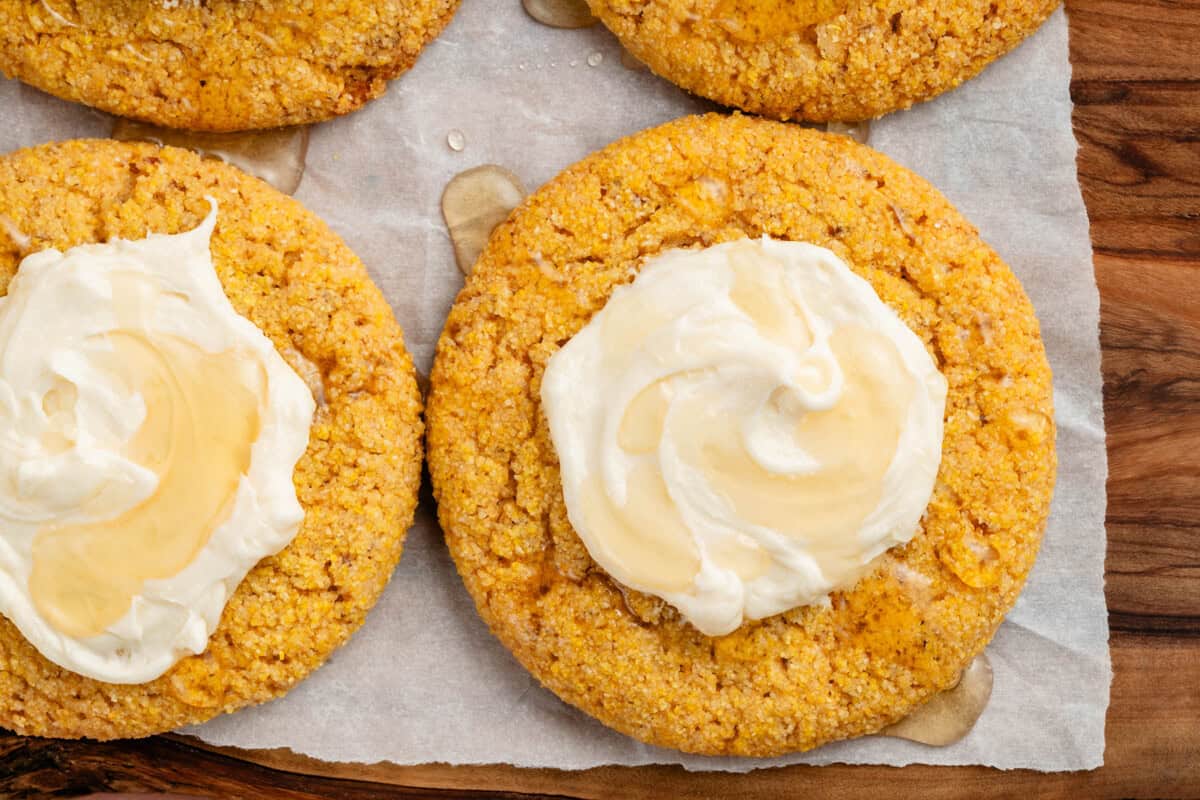 vegan cornbread cookies with agave buttercream on wooden platter with parchment paper