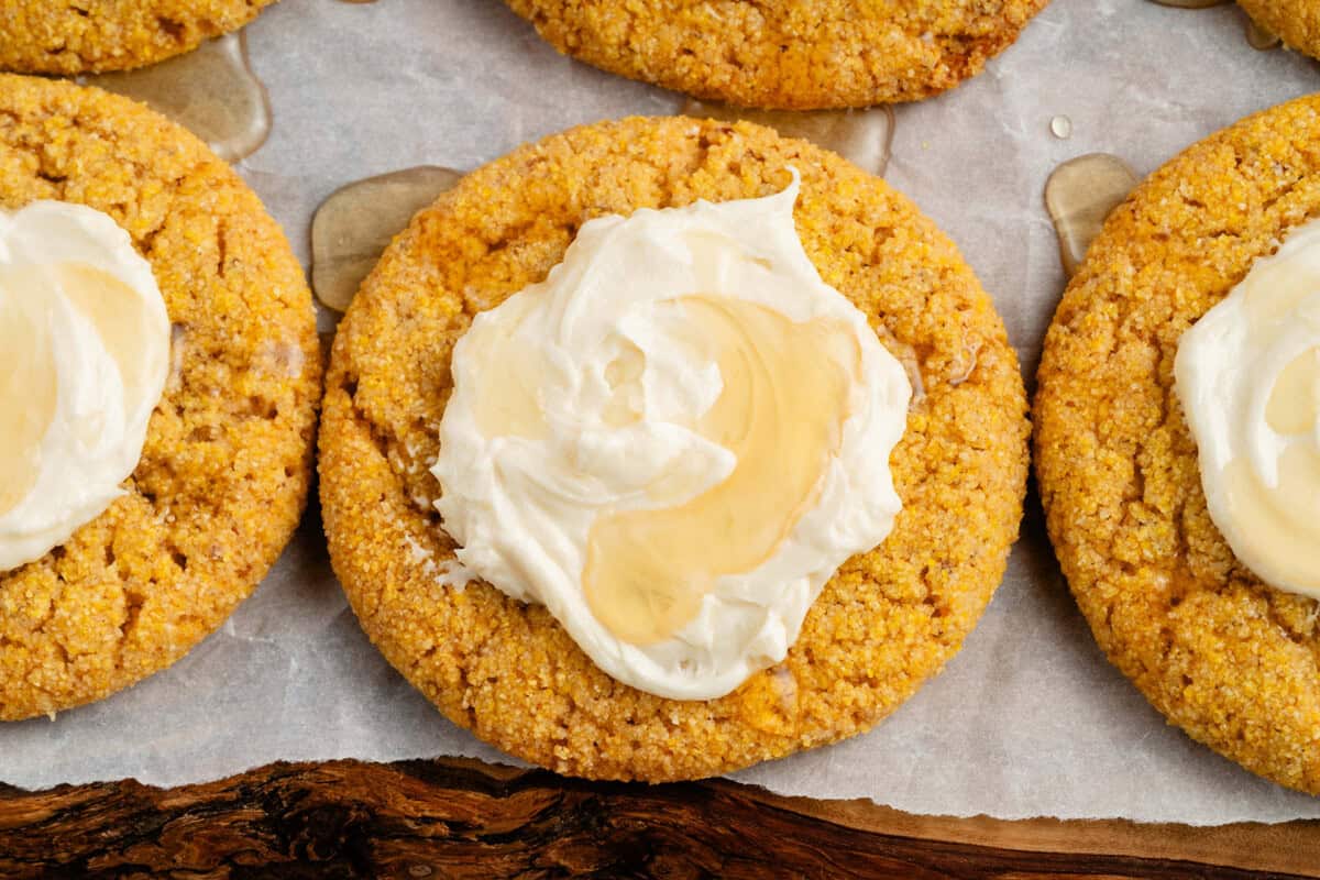 vegan cornbread cookies with agave buttercream on wooden platter with parchment paper