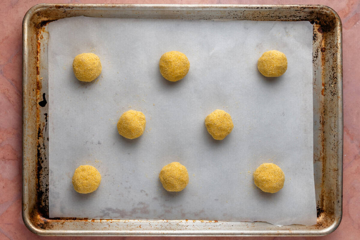 balls of cookie dough on lined baking sheet