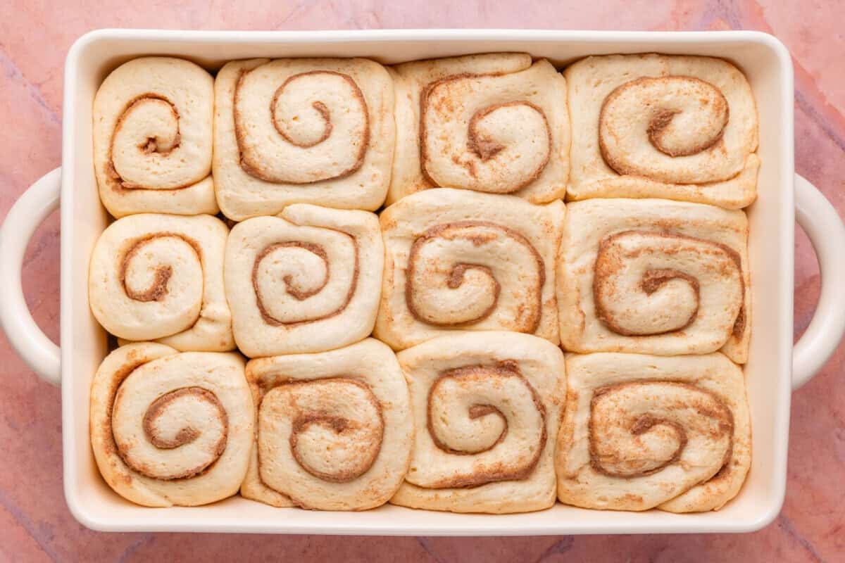 overhead of risen buns in a baking dish