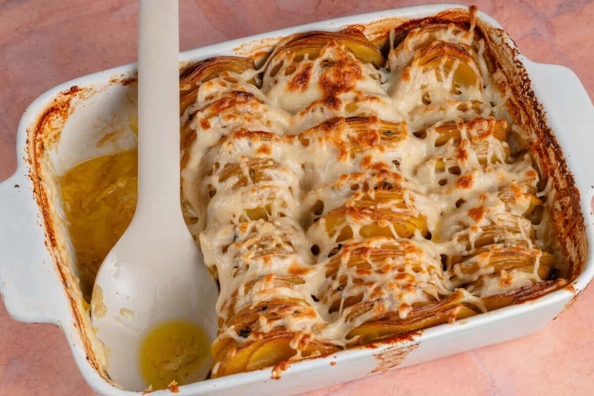 baking dish with Dauphinoise Potatoes and a row missing with a spoon