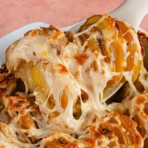 scooping Vegan Dauphinoise Potatoes from the baking dish