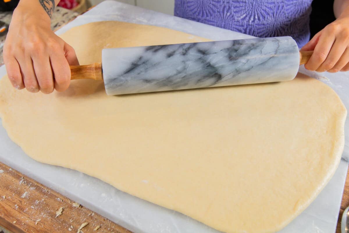 rolling out the dough with a marble rolling pin