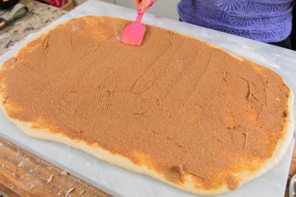 spreading the cinnamon sugar filling on the dough