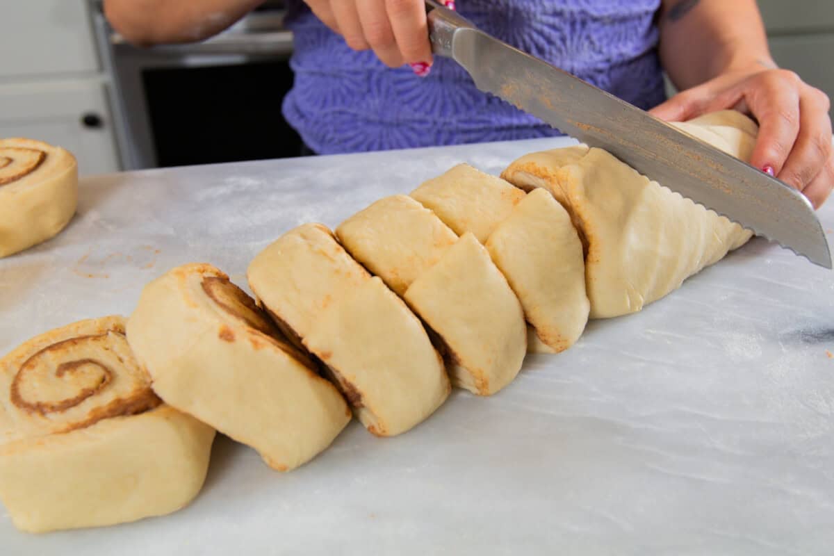 cutting the maple pecan sticky bun log with a serrated knife