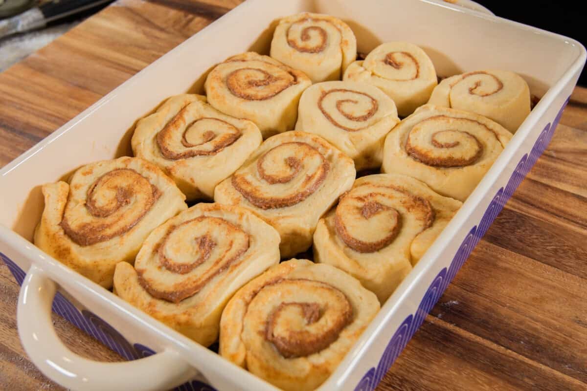 cut maple pecan sticky bun rolls in a baking dish before being baked